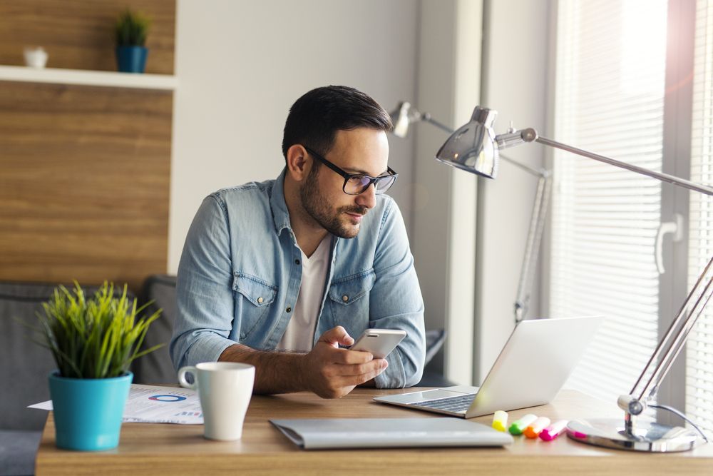 Man using smartphone and laptop